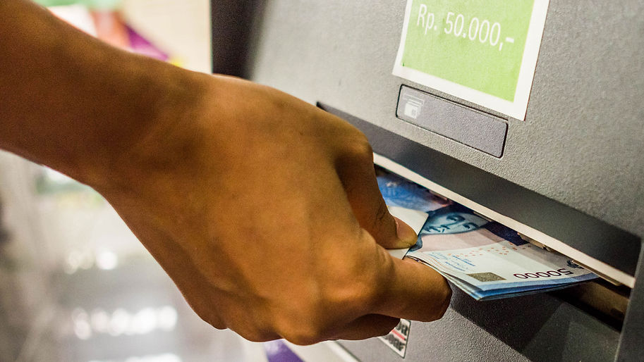 Hand withdrawing money from an ATM, symbolizing the international remittance service for withdrawal abroad