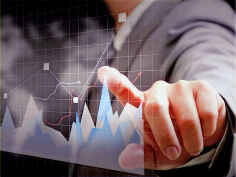Uma mão apontando para uma tela com gráficos financeiros