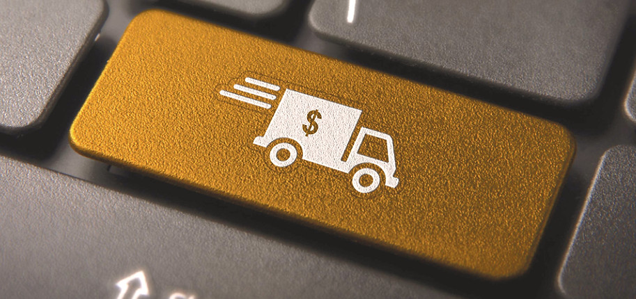 Tecla dourada de um teclado com o símbolo de um caminhão de delivery de dinheiro, representando a opção de receber moedas estrangeiras em casa